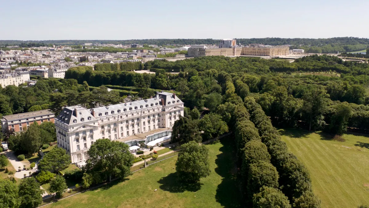 Waldorf Astoria Trianon Palace from the air with the Palace of Versailles beyond