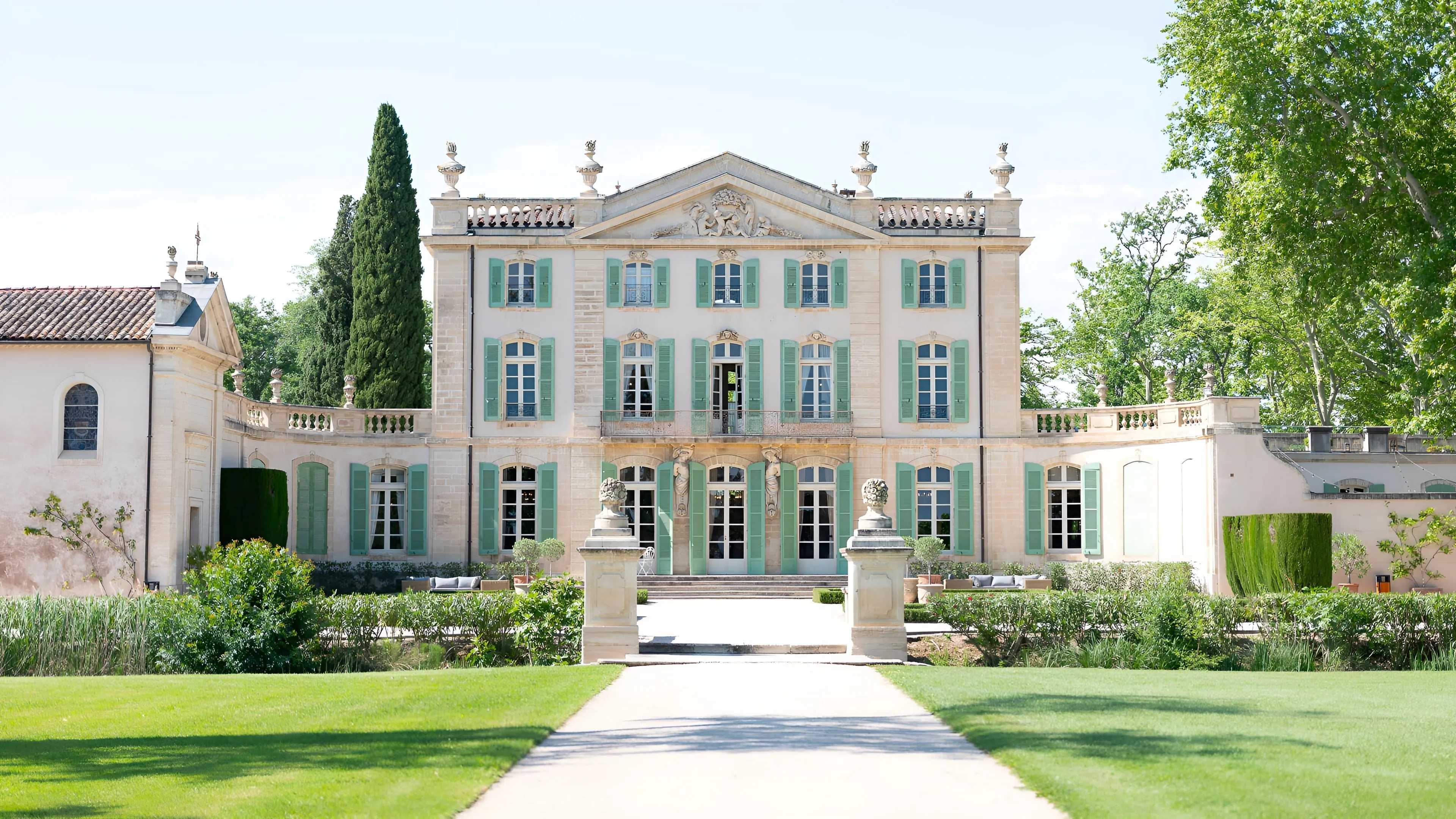 The south façade of Château de Tourreau, its shuttered 18th-century stone front rising beyond the formal lawn and gravel path